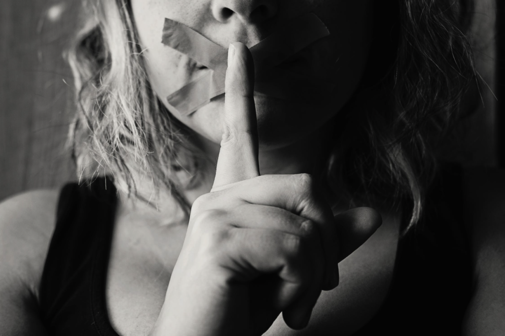 woman placing her finger on her lips
