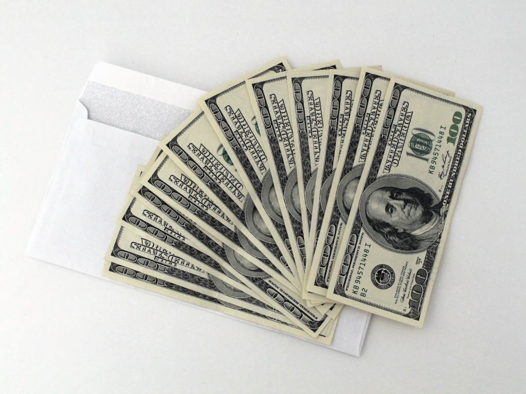 money on top of white envelope