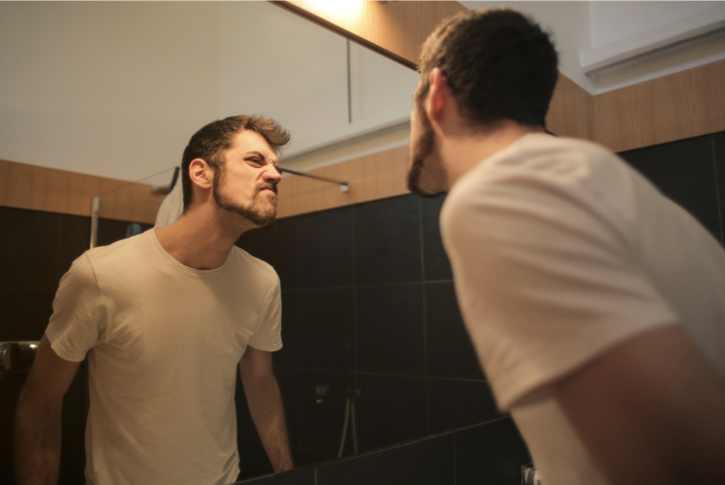 man looking at bathroom mirror