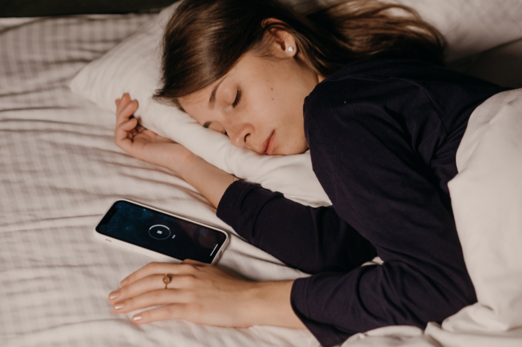 woman sleeping beside her phone