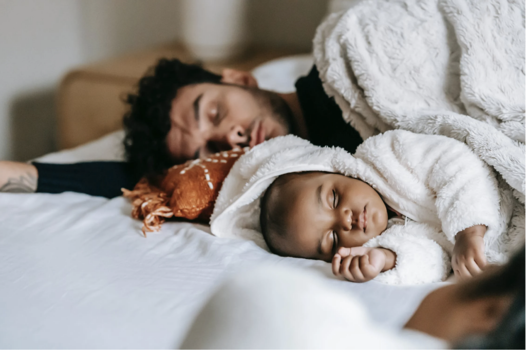 man and infant sleeping