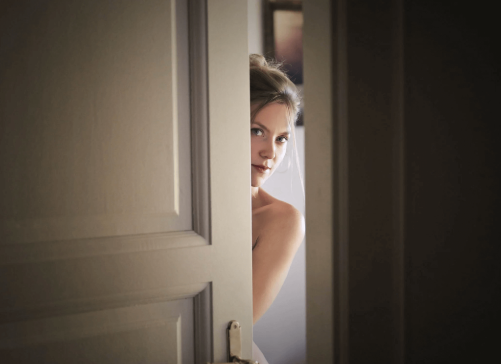 woman peeking behind a door