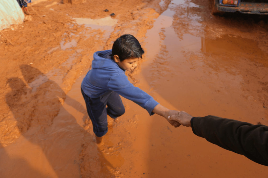 hand reaching out to help a kid stuck in mud