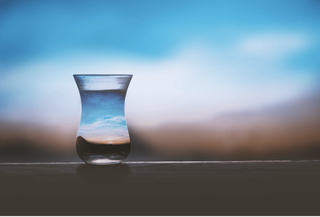 glass of water reflecting the sky background