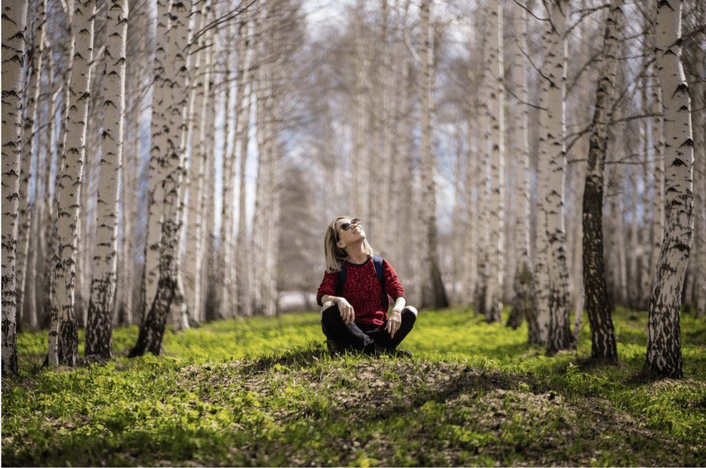 woman sitting in the middle of the woods